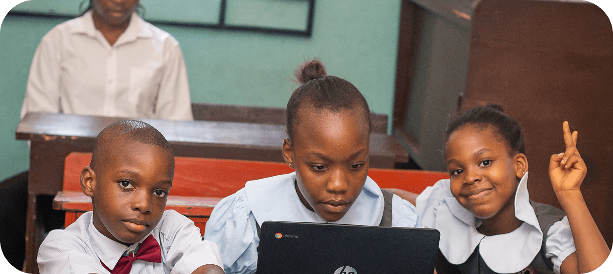 Mentor and children learning with laptops at a table