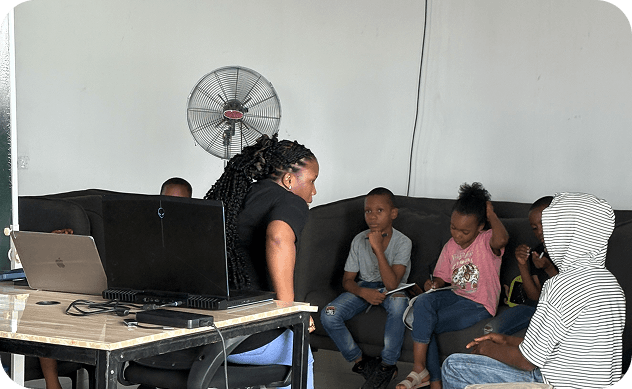 Children and mentor collaborating on a coding activity