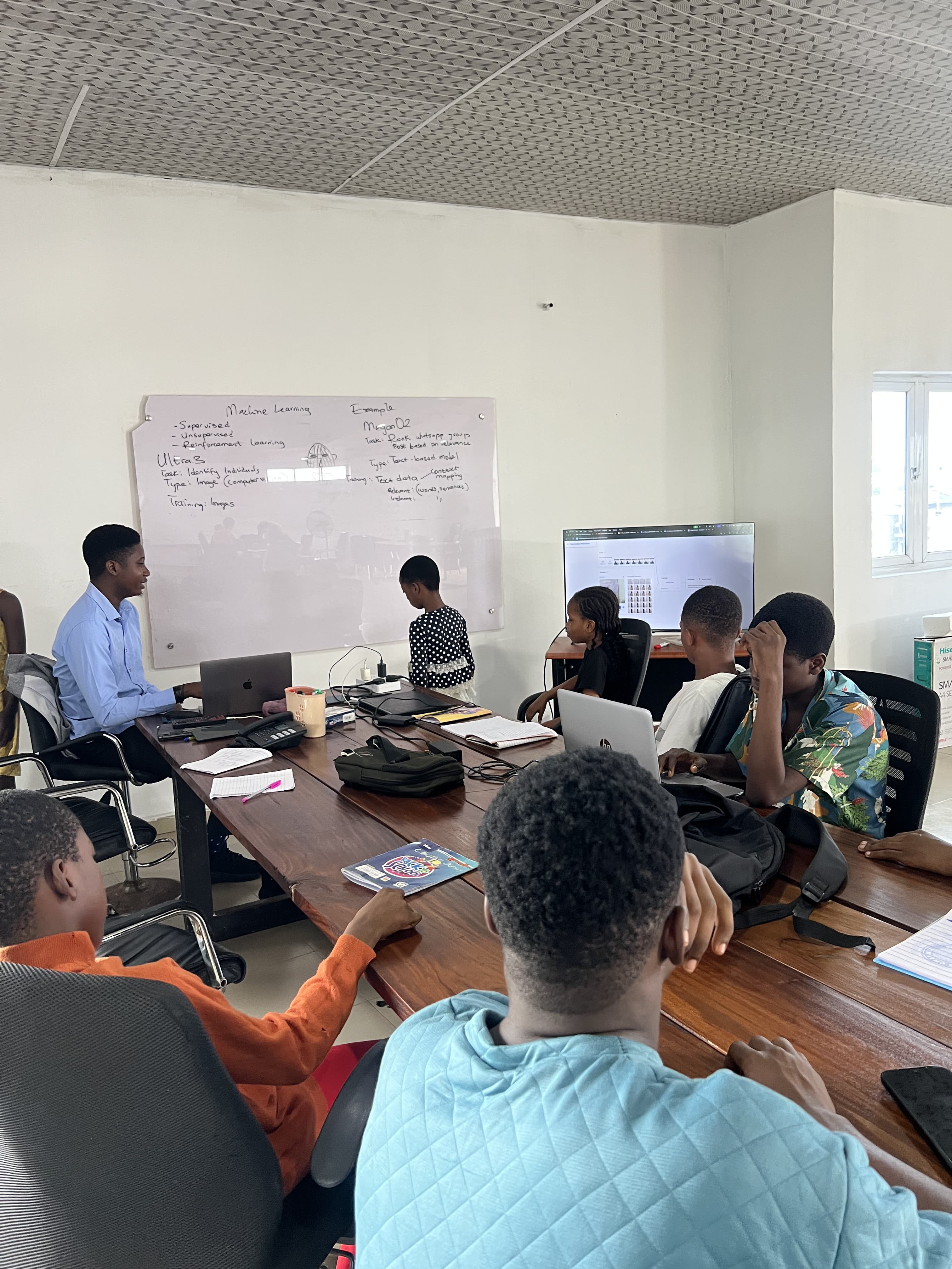 Mentor and children learning with laptops at a table